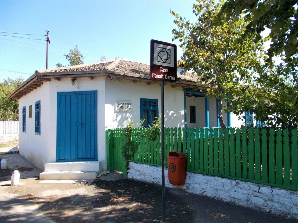 Casa memorială Panait Cerna — casă mică, văruită în alb, cu uși albastre și gard verde de șipci