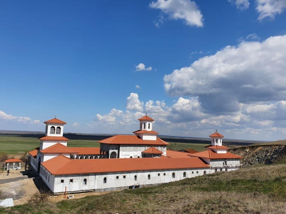Incinta Mănăstirii Dinogeția, cu clădiri lungi și acoperișuri de țiglă roșie