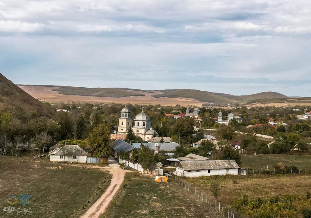 Satul Slava Rusă văzut de pe deal, cu biserica Mănăstirii Vovidenia între case și grădini